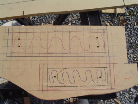 1999 Ford Taurus - A cardboard template marked up in red and blue with two rectangular openings and serpentine layout lines, drilled reference holes at the co…