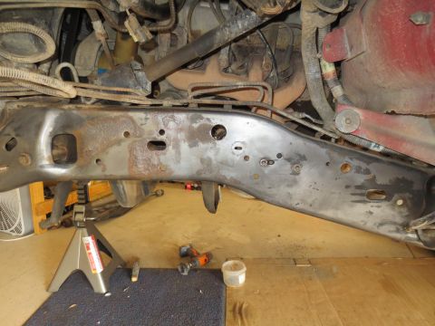 1996 Ford Bronco - Close-up view of a vehicle's frame and engine components, supported by jack stands.