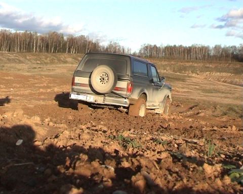 1987 Ford Bronco - This 1987 Ford Bronco is stuck deep in the mud, with its rear end angled downwards.