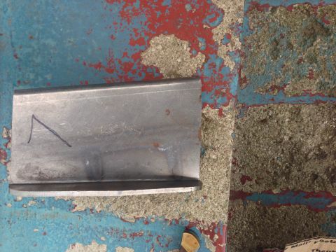 1979 Ford Bronco - Metal bracket with a blue marker line on a textured, painted surface.