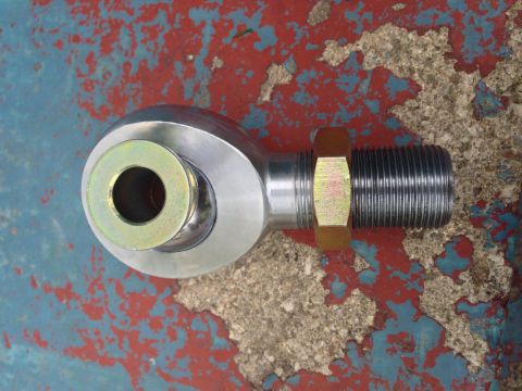 1979 Ford Bronco - A close-up view of a metal rod end joint with a threaded shaft and hex nut, set against a distressed painted background.