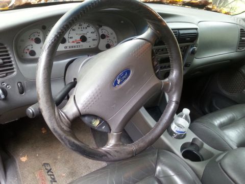 2001 Ford Explorer - The interior of a Ford Explorer shows the dashboard, steering wheel, and a water bottle in the cup holder.