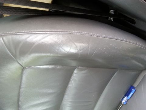 2001 Ford Explorer - Interior view of a worn gray leather car seat, showing texture and creasing.