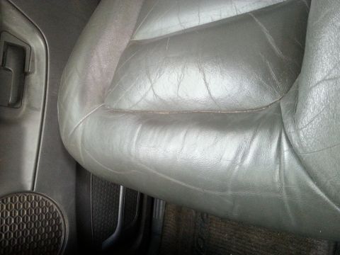 2001 Ford Explorer - A close-up view of the driver's seat interior, showing the texture and wear of the leather upholstery.