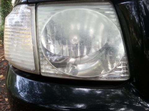 2001 Ford Explorer - Headlight assembly detail on a dark vehicle.