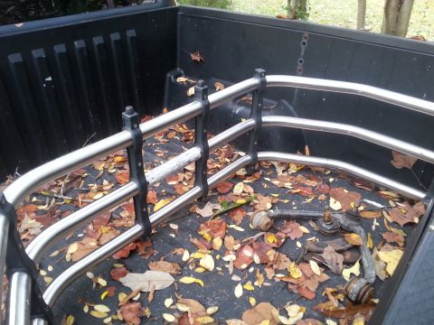 2001 Ford Explorer - Suspension parts and tie-down rails in a truck bed covered with autumn leaves.