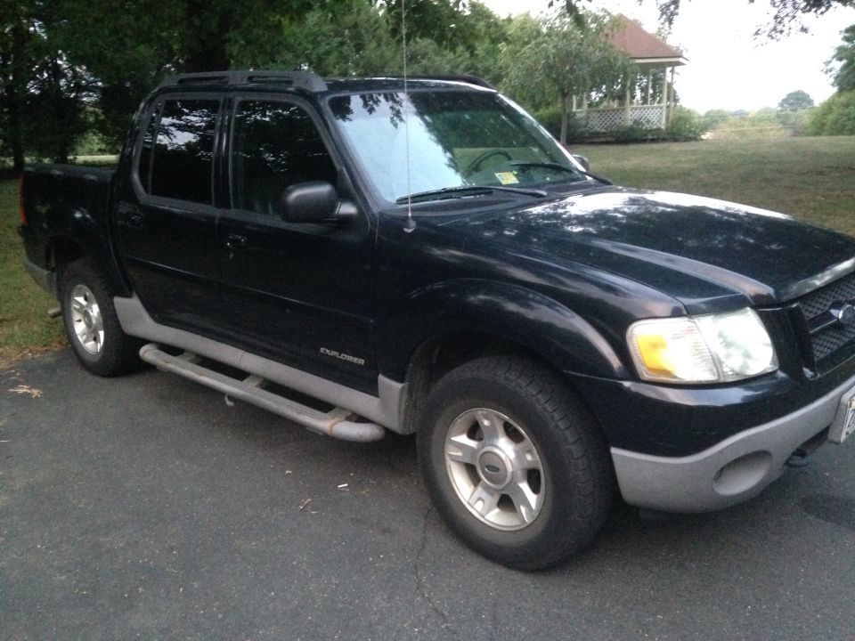Black 2001 Ford Explorer Sport Trac parked on asphalt driveway.