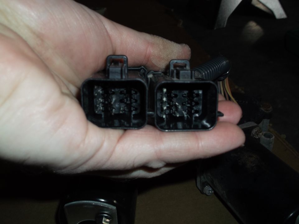 Close-up of two black electrical connectors with pins.