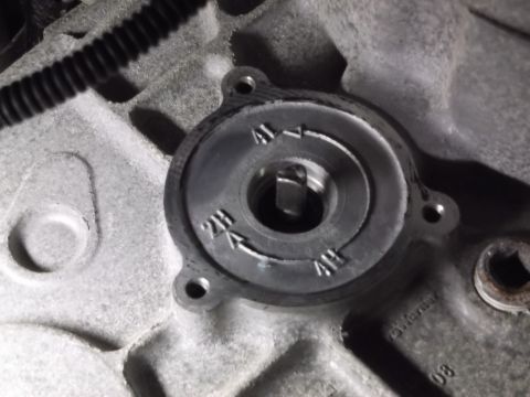 2005 Ford F-150 - A close-up view of a transfer case shift mechanism with markings for 2H, 4H, and 4L. The metal casing of the transfer case is visible, alon…