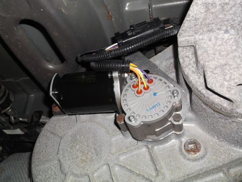 2005 Ford F-150 - A close-up view of a transfer case motor and actuator assembly attached to a vehicle's drivetrain. The assembly includes a black motor with…