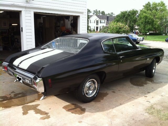 Black 1970 Chevrolet Chevelle SS with white racing stripes, parked in driveway.
