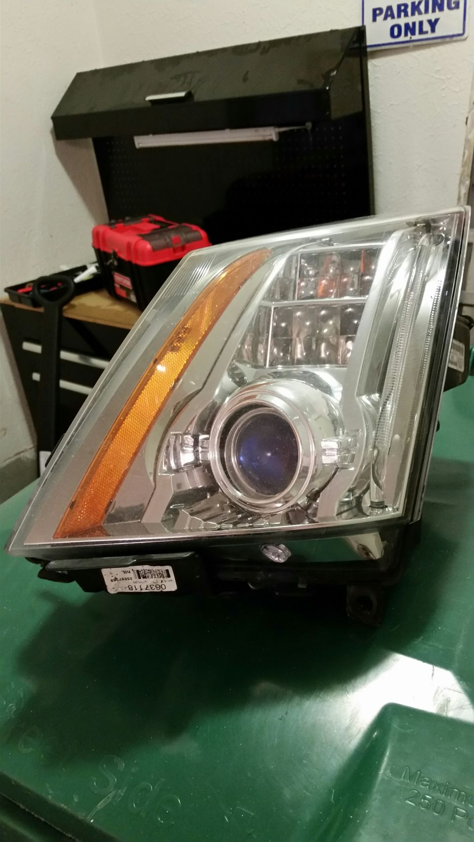 Car headlight assembly with projector lens and amber turn signal.