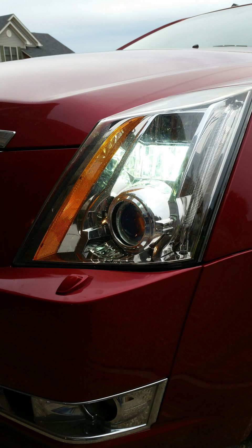 Red Cadillac CTS passenger side headlight with amber turn signal.