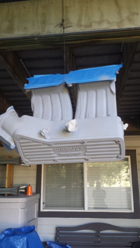 1996 Ford Bronco - A gray, dual-plane intake manifold with blue tape on top is suspended by wires from a wooden beam. The manifold has "Edelbrock PERFORMER" t…