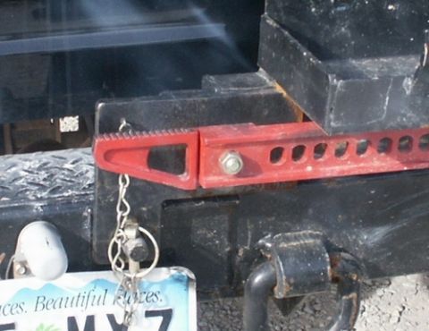 1990 Ford Bronco - Swing arm attached to Bumper. The swing arm rests on the bumper, and a cotter pin holds the arm on the pin. There is a chain that holds the…