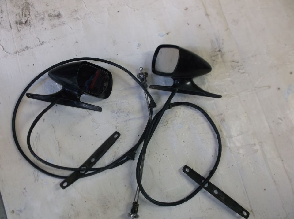 Two black side mirrors with cables on a white surface.