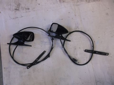 1979 Ford Ranchero - Two black side mirrors with cables are laid out on a textured surface. One mirror is on the left and the other is on the right, with a blac…