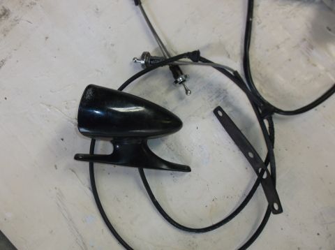 1979 Ford Ranchero - A black, teardrop-shaped automotive part, possibly a headlight or marker light, is shown with black wiring and a metal bracket on a texture…
