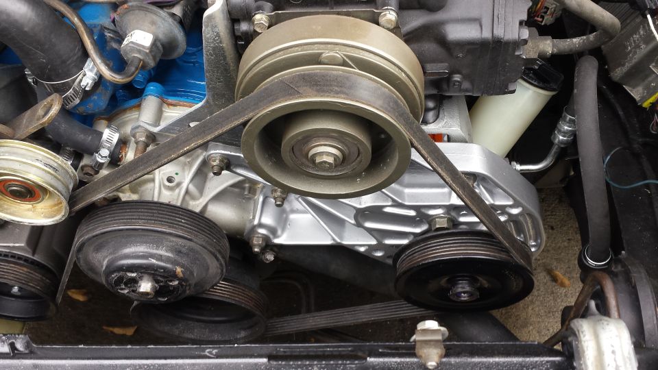 Serpentine belt system on a V8 engine with multiple pulleys.