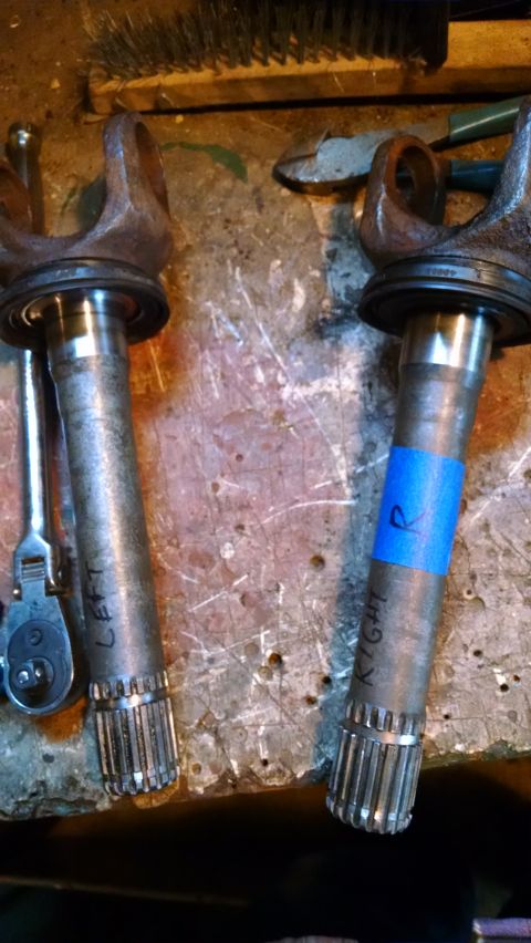 1994 Ford Bronco - Two driveshaft yokes are laid out on a workbench. The left yoke has "LEFT" written on it, and the right yoke has blue tape with an "R" writ…