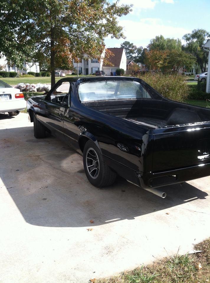 Black Chevrolet El Camino parked on a driveway, rear passenger side view.