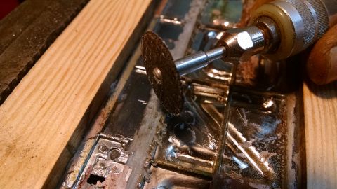 1992 Ford Bronco - A close-up shot shows a rotary tool with a cutting disc being used to grind away at a metal object. The object appears to be part of a larg…