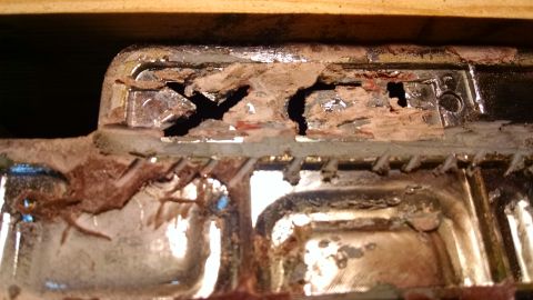 1992 Ford Bronco - This is a close-up, detailed view of a heavily corroded and damaged chrome-plated part, possibly from a vehicle's radiator or grille surrou…