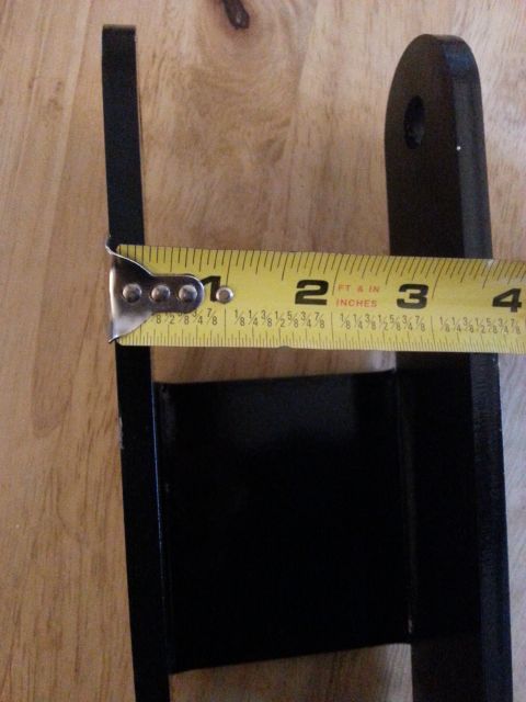 2001 Ford Explorer - A metal bracket is measured against a yellow tape measure that reads approximately 2 and 3/4 inches. The bracket is black and appears to be…