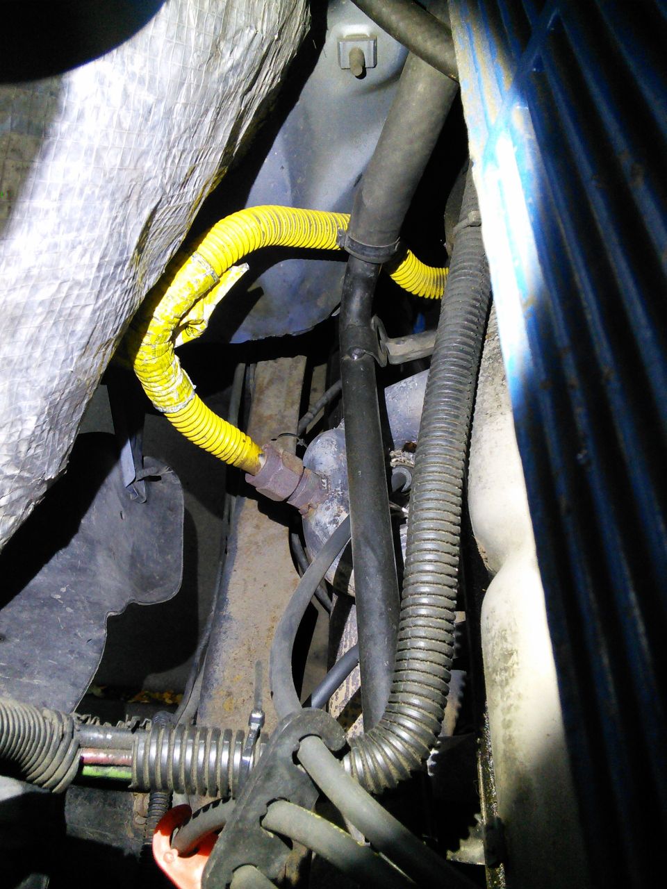 Yellow and black hoses and wiring looms in an engine bay.