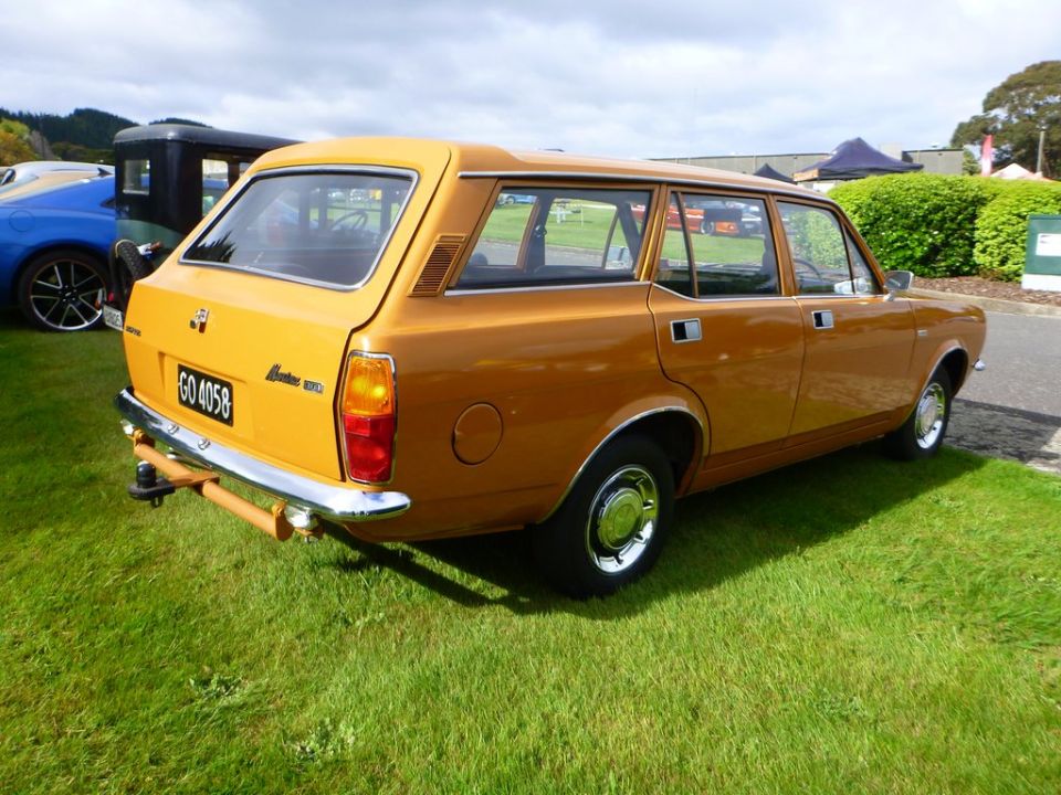 Rear passenger side view of an orange station wagon with license plate GO 4058.