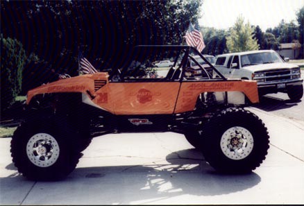 1990 Ford Bronco - Custom buggy with 'AVALANCHE' graphics sits beside a white SUV.