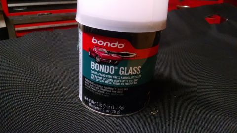 1992 Ford Bronco - A can of Bondo Glass short strand reinforced fiberglass filler is shown with its white plastic lid on. The can has red, green, and black la…