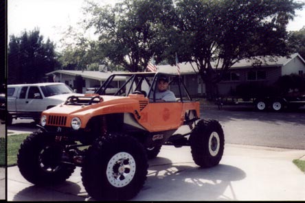 1990 Ford Bronco - A custom-built buggy with a roll cage and oversized tires sits in a suburban driveway.