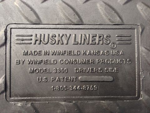 1979 Ford Bronco - This is a close-up of a Husky Liners floor mat, showing manufacturing details and a customer service number.
