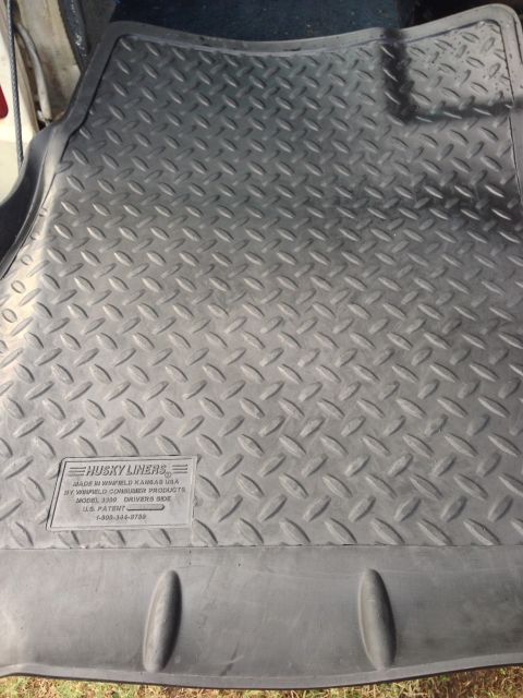 1979 Ford Bronco - A close-up view of a black Husky Liners rubber floor mat with a diamond plate pattern.