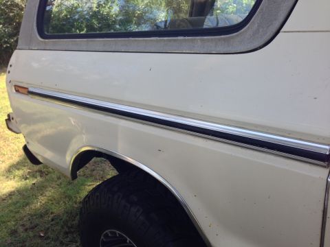 1979 Ford Bronco - A white SUV, likely a 1978 model, is viewed from the side, revealing its chrome trim and fender flare.