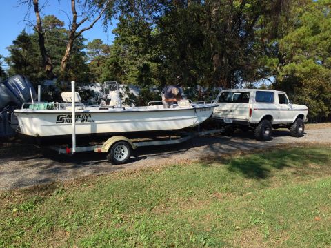 1979 Ford Bronco - A white 1978 Ford Bronco is seen from the rear, towing a boat on a trailer.