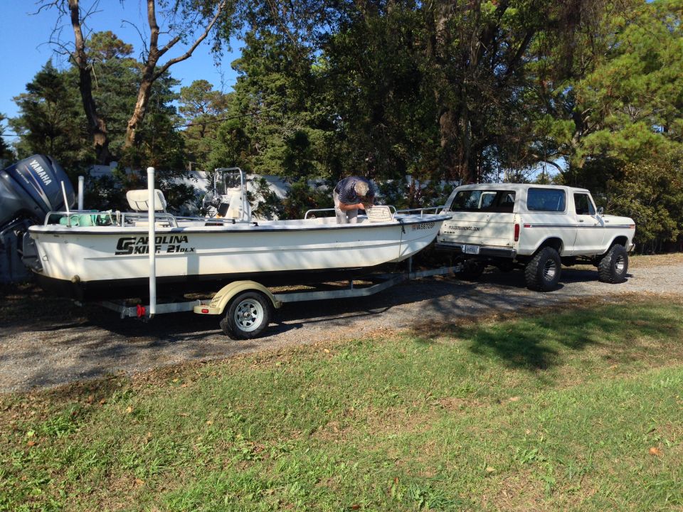 White 1978 Ford Bronco with boat trailer, rear view