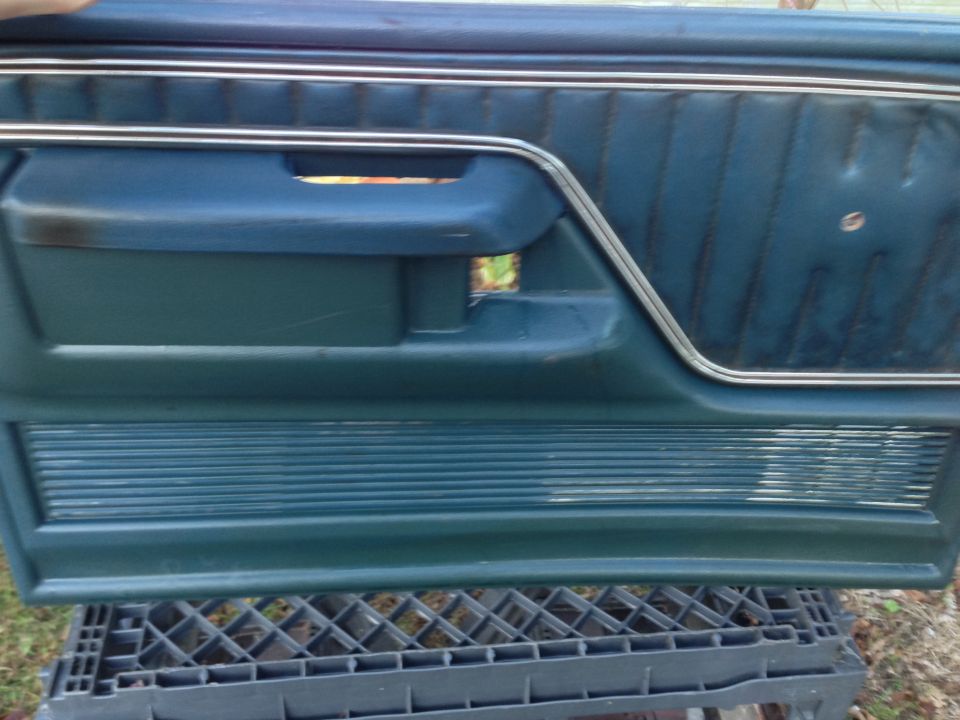 Blue 1979 Ford Bronco interior door panel with chrome trim