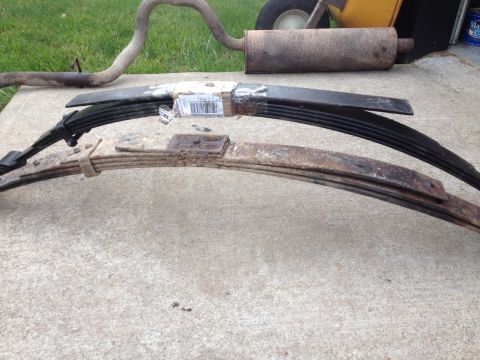 1996 Ford Bronco - Leaf springs and exhaust pipe components are shown on a concrete surface.