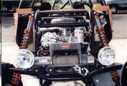 1990 Ford Bronco - An off-road vehicle's front end is shown with its engine and winch exposed.