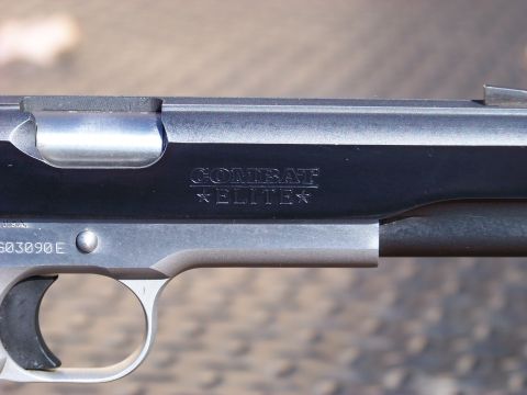 1995 Mercury Grand Marquis - A close-up view of the slide and frame of a pistol, showing the engraved text "COMBAT ELITE" and a serial number "G03090E".