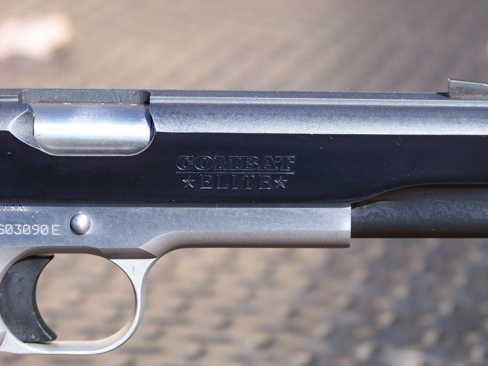 Close-up of a pistol slide with "COMBAT ELITE" engraving and serial number G03090E.