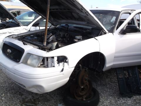 1999 Mercury Grand Marquis - A white 1999 Mercury Grand Marquis with its hood open, revealing the engine bay. The front bumper has visible damage, and the front passeng…