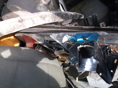 1999 Mercury Grand Marquis - A pile of disassembled car parts, including a blue reflector and black plastic housing, are seen inside what appears to be a vehicle's inte…
