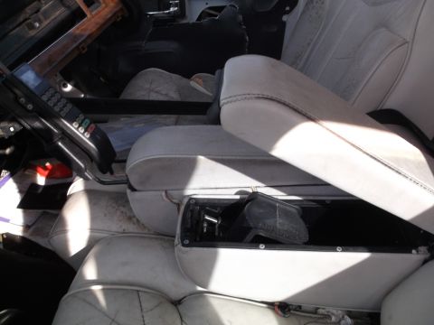 1999 Mercury Grand Marquis - The interior of a vehicle shows a car phone mounted to the dashboard and a center console with an open storage compartment. The seats appea…
