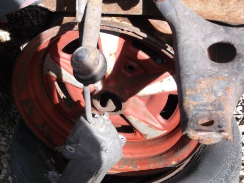 1999 Mercury Grand Marquis - A close-up view of a red wheel with a brake caliper and suspension components. The wheel has a multi-spoke design and appears to be part of…