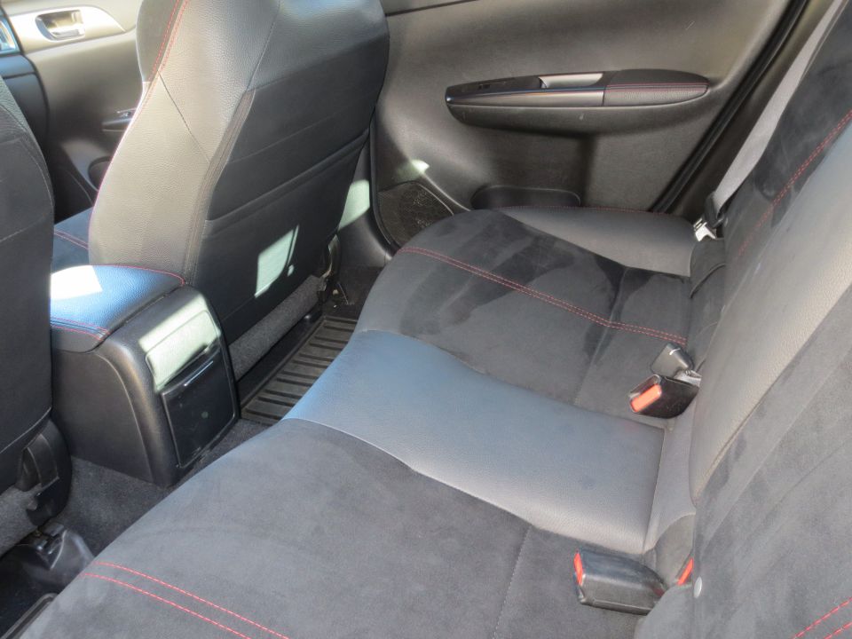 Black car back seat with red stitching and center console