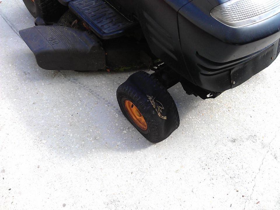 Flat tire on a black riding lawn mower