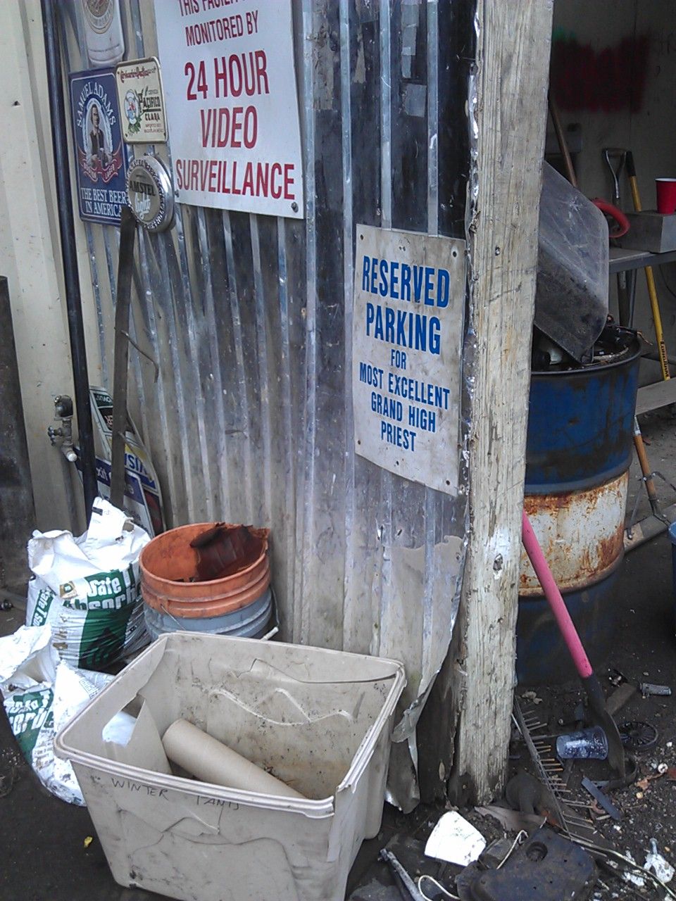 Corrugated metal wall with surveillance and parking signs, and a bin labeled "WINTER LAND".